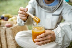 Beekeeper tasting honey outdoors